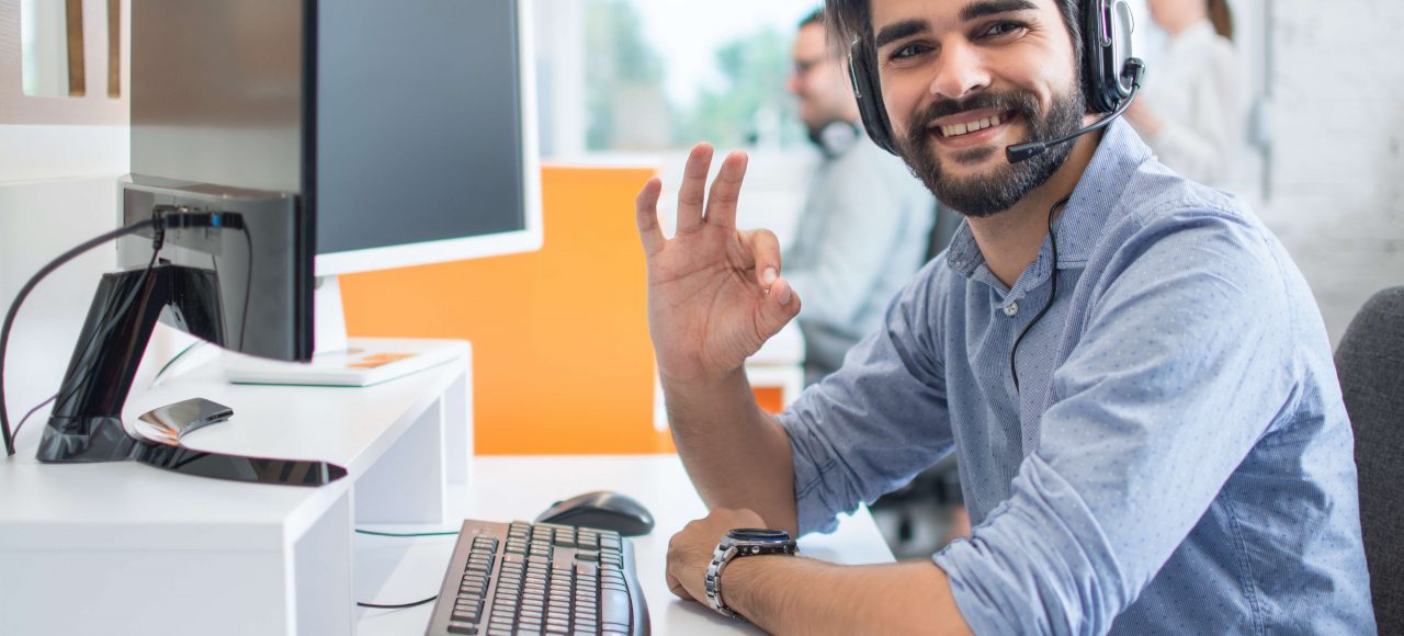 man with headset on sat at desk